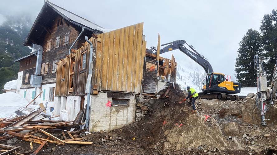 An outdoor construction site of the Gepatschhaus showing a crane and piles of wood